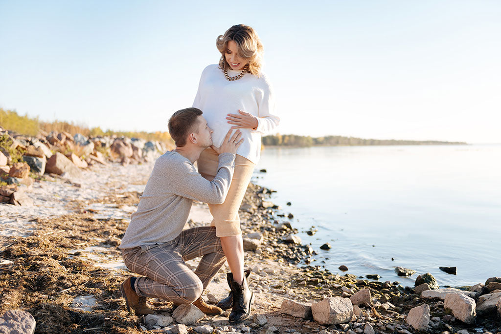 Young couple on their babymoon vacation on the beach.
